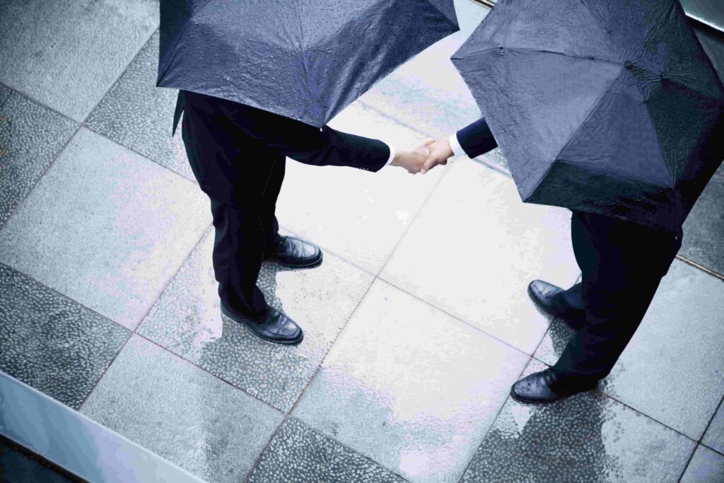 Handshake in the Rain with Umbrellas