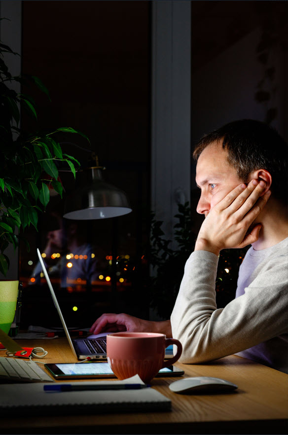 A concerned man considering information presented on a laptop