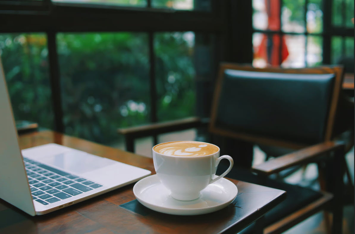 Coffee, a laptop, and an open chair prepared for a conversation
